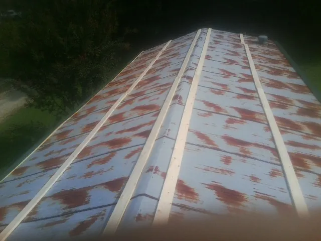 Rusted metal roof panels with new wood purlins before replacement — Storm Damage Roof Repair in Kingston Springs by Roofing Brothers