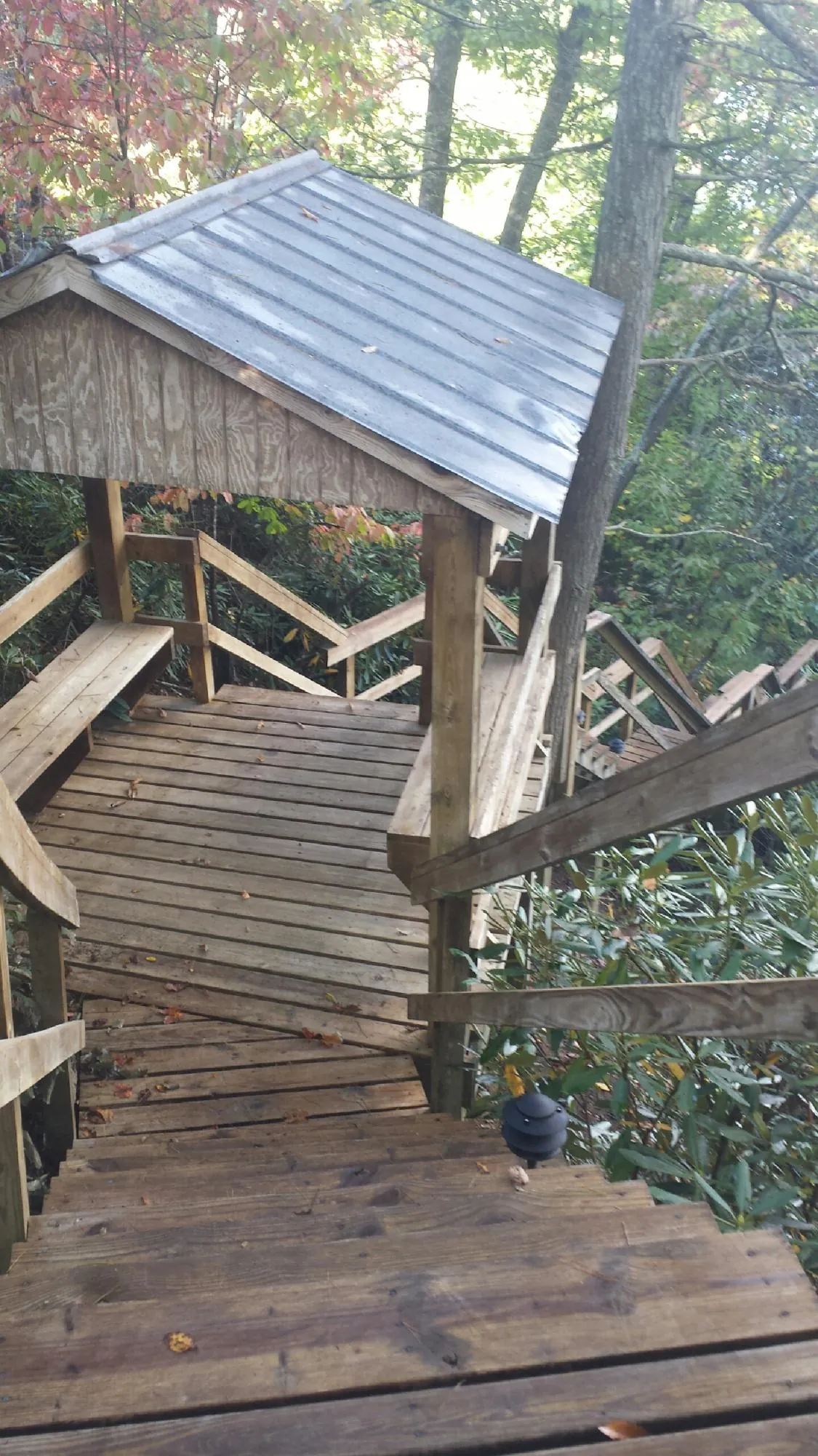Metal roofed shelter over wooden steps on a wooded walkway — Skylight Repair & Installation work by our crew in Kingston Springs