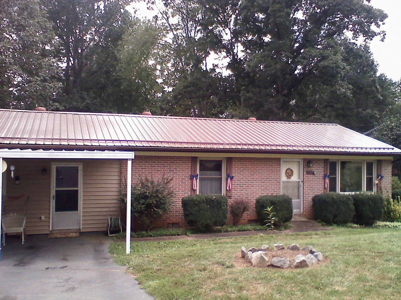 Bronze metal roof and carport on a brick ranch home — Roof Repair work by our crew in Kingston Springs